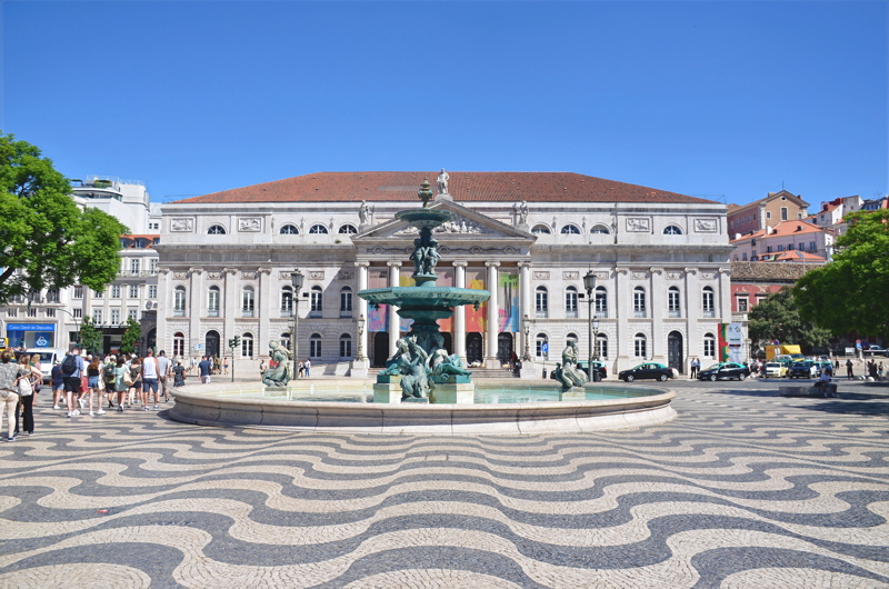 10 - Rossio Square in Lisbon, Portugal, featuring the neoclassical Teatro Nacional D. Maria II and one of its iconic monumental bronze fountains